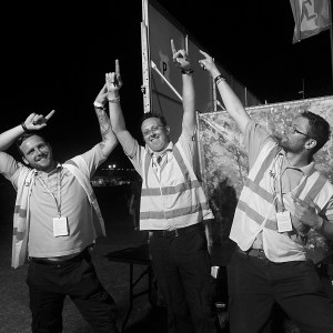 Three security guards dancing at a festival