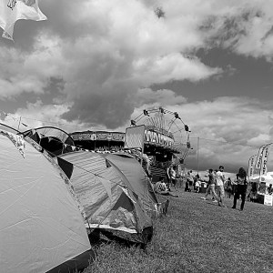 Festival campsite with tents in the foreground and a big wheel in the background