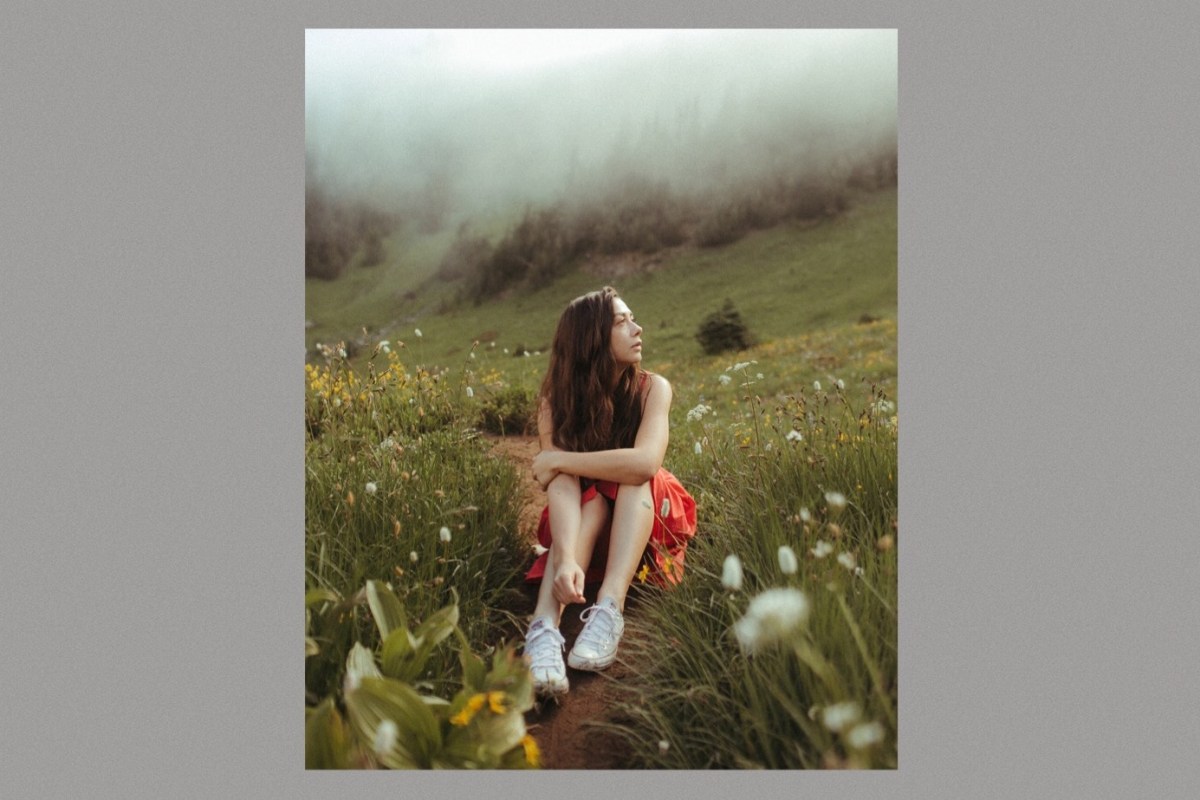 Danielle Durack wearing a red dress sitting in a field