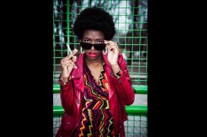 Model in red jacket looking over sunglasses